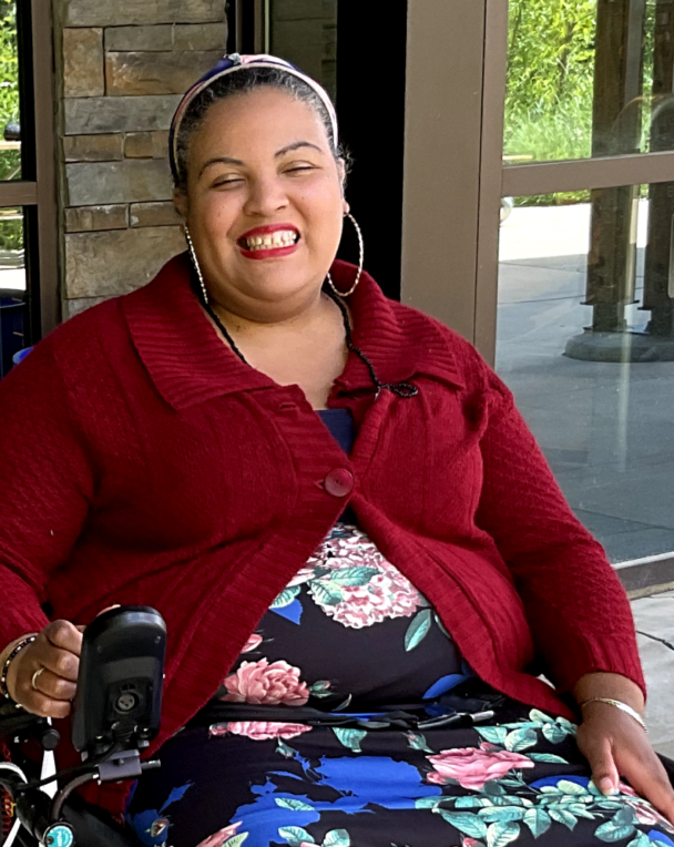 A female AWB member wearing a red sweater, smiling for a photo.