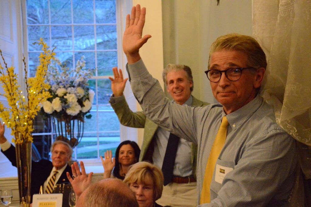 A group of people at an AWB event, raising their hands.