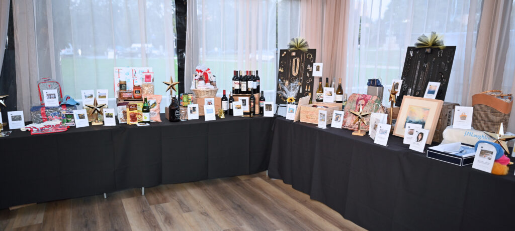 A long table full of gift baskets and donations.